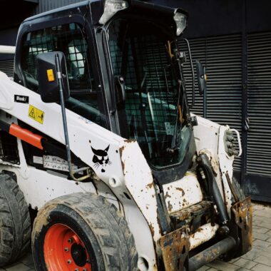 Construction machinery waiting for installation of spare parts and overhauling on paving stones parking